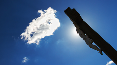 Crucifixion. Christian cross with Jesus Christ statue over stormy clouds. religion and spirituality concept.の写真素材