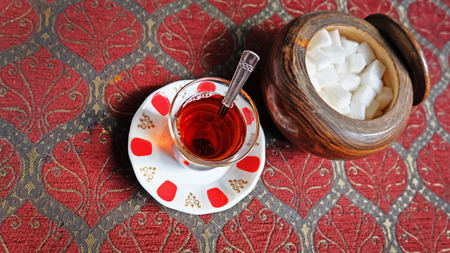 Black Turkish tea in traditional glass with sugar in wooden bowlの写真素材