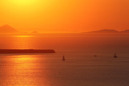 Sunset in orange color on the sea near Santorini islandの写真素材