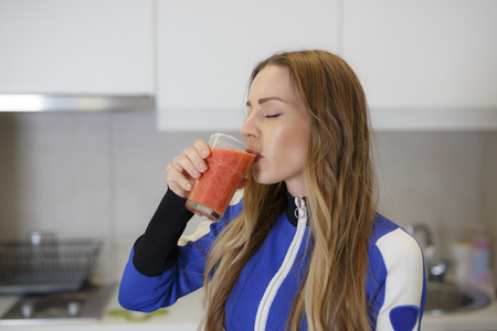 Attractive Girl in Sportswear Drinking Tasty Smoothieの写真素材