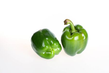 Two green bell peppers isolated on whiteの写真素材