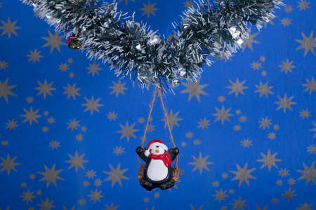 Creative layout,Christmas decorations,a penguin on a swing with starry sky backgroundの写真素材
