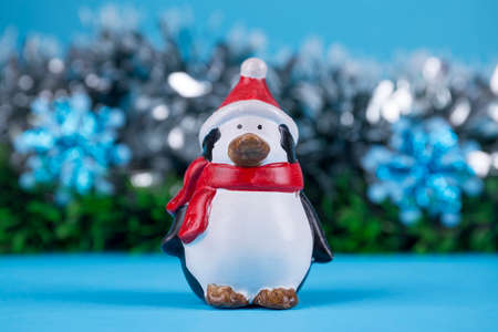 Penguin doll with Christmas decorations on blue backgroundの写真素材