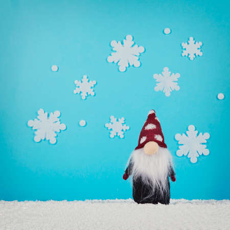 Santa Claus doll with snowflakes on bright blue background. Minimal winter holiday scene.の写真素材