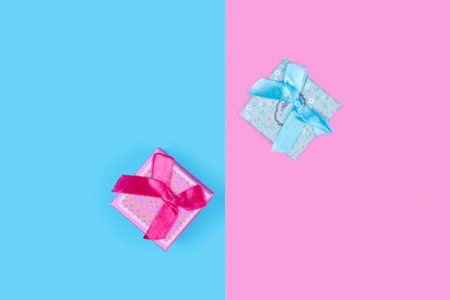Small colorful gift boxes. Minimal composition on pastel pink and blue backgroundの写真素材