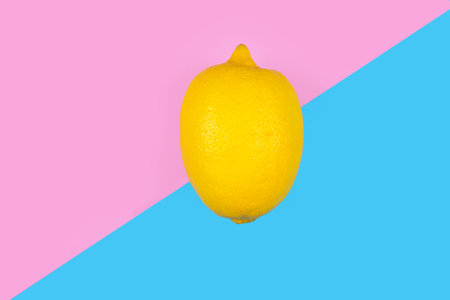Lemon fruit on pastel pink and blue background. Minimal summer concept.の写真素材