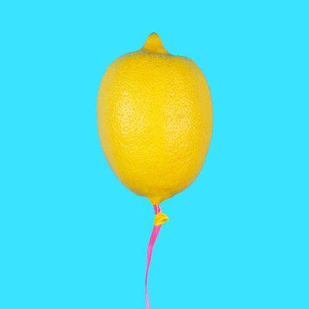 Lemon balloon on light blue background. Minimal summer fruit concept.の写真素材