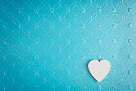 White heart on pastel textured blue background. Minimal Valentines day concept.