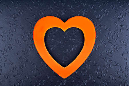Orange heart on black textured  background. Minimal Valentines day concept.の写真素材