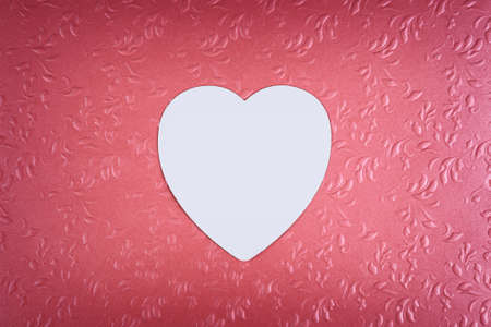 White heart on pastel textured pink background. Minimal Valentines day concept.