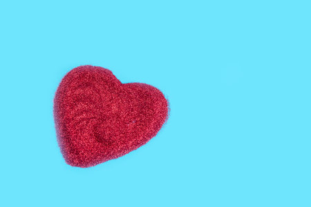 Heart shaped of red glitter on light blue backgroundの写真素材