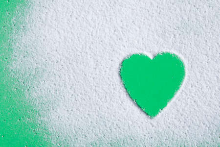 Heart shaped of powdered sugar on greenの写真素材