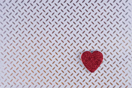 Red heart on metallic textured  background. Minimal Valentines day layout.の写真素材