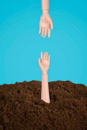 Two doll hands reaching one another. Helping hand minimal concept.の写真素材