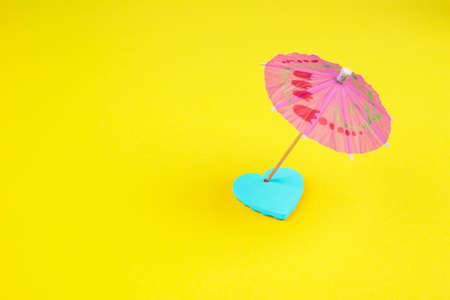 Colorful umbrella and heart on a yellow background. Summer concept.の写真素材