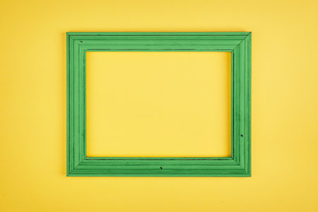 Simple green frame on bright yellow background. Minimal border composition.の写真素材