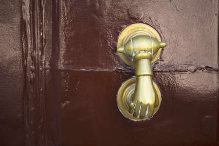 Old iron door knob on aged brown door