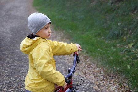 Kid boy of 6 years with bicycle on park road. Healthy lifestyle, environmentally transport concept.の写真素材