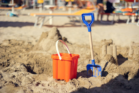 Childrens bucket and shovel, castle of sand on the sand beach on a sunny day.の写真素材