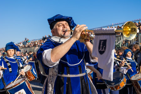 Menton, France-February 12, 2023: man playing trumpet in a traditional marching band with members in...