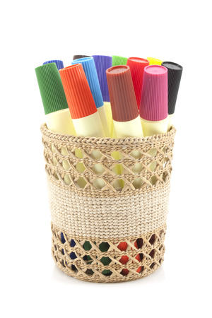 colored markers in basket on the white backgroundの写真素材