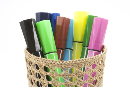 colored markers in basket on the white backgroundの写真素材