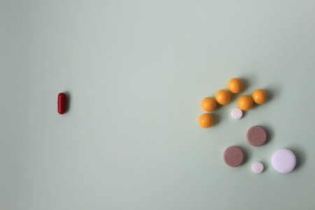 Colorful vitamin pills, medicine tablets and capsules on an abstract green background.の写真素材