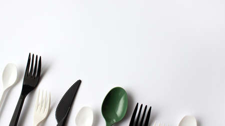 Disposable plastic cutlery on a white background. Place for text. Environmental problem,...