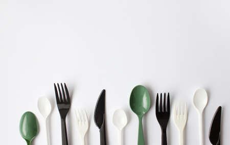Color plastic cutlery on a white background. Place for text. Environmental problem, environmental...