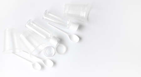 disposable plastic tableware on a white background. Environmental pollution. Space for textの写真素材