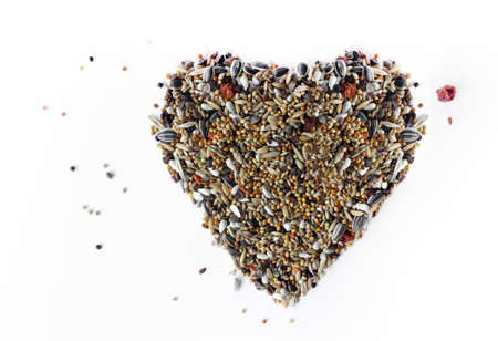 heart made of bird grain isolated on white backgroundの写真素材