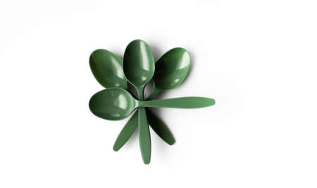 Green plastic spoons lie on top of each other on white isolated backgroundの写真素材