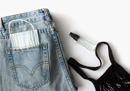 flat lay of womens things and accessories on a white background. Blue jeans, reusable bag, medical...