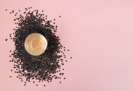 Fresh sesame seed and cosmetics sesame oil on pink background. Top view. Beauty flatlay.の写真素材