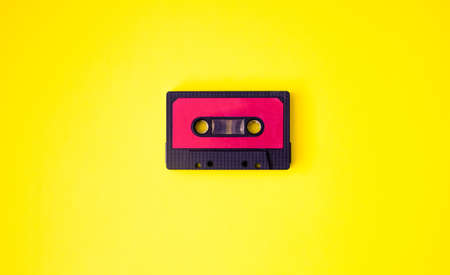 Black music cassette on yellow background. Space for text. Retro conceptの写真素材