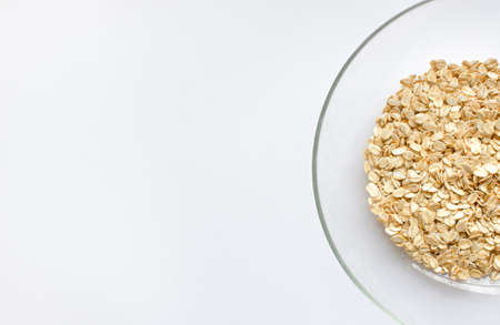 oat cereals in a glass bowl on a white background. View from above. Place for text. healthy eating concept.の写真素材