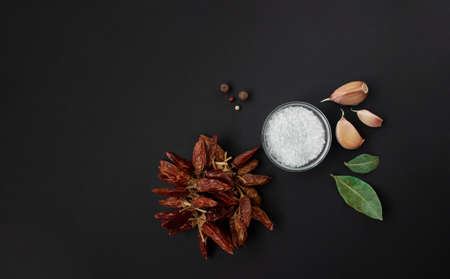 isolated spices on black background, garlic, salt, bay leaves and hot red pepper - spices...