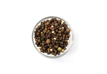 Pepper mix. Black, red and white peppercorns in a glass cup, isolated on white background. Close-up.