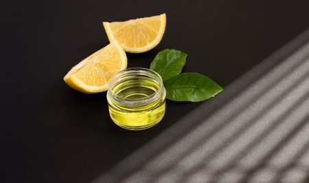 Lemon slices and cosmetic lemon oil on a black background. Close up.の写真素材