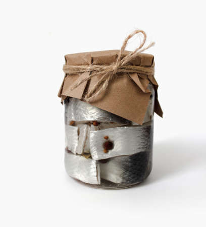 Sliced salted herring fish with pepper in jar isolated on white backgroundの写真素材