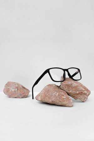 glasses on gray background wjth stone. glasses sale concept. Copy space for text. Optic store...
