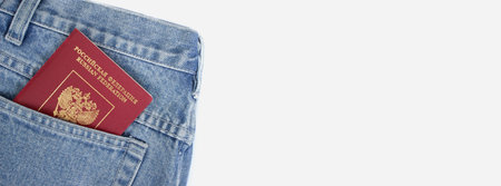 Russian passport in a jeans pocket on a white background, banner, space for textの写真素材