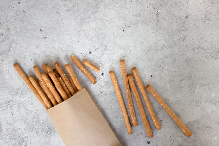 Bread sticks, with sesame seeds and whole grain flour on grey background. Top view, copy space.の写真素材