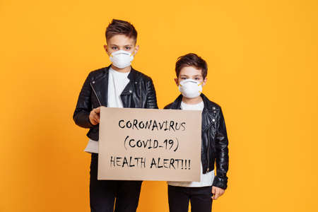 People wearing protective face masks and jolding the sign "Coronovirus (covid-19) Health allert"の写真素材