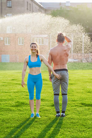 Incredibly beautiful, athletic girl does exercises at the sports city stadium on a warm summer evening. Making a stand upside down on hands.の写真素材
