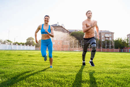 Athletic muscled young woman in a sports wearing doing fitness exercises. Fitness woman posing at the stadium. Healthy athletic lifestyle.の写真素材