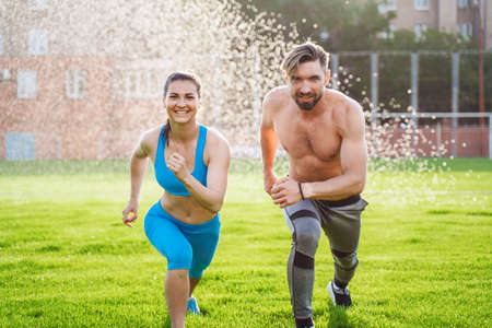 Athletic muscled young woman in a sports wearing doing fitness exercises. Fitness woman posing at the stadium. Healthy athletic lifestyle.の写真素材