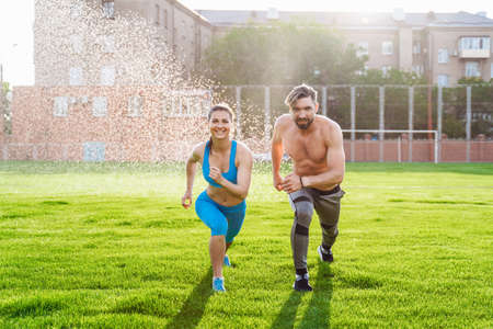 Athletic muscled young woman in a sports wearing doing fitness exercises. Fitness woman posing at the stadium. Healthy athletic lifestyle.の写真素材