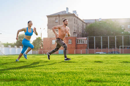 Athletic muscled young woman in a sports wearing doing fitness exercises. Fitness woman posing at the stadium. Healthy athletic lifestyle.の写真素材