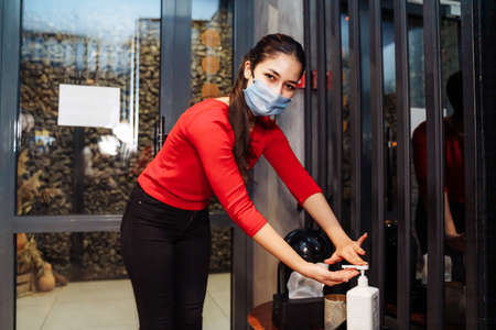 Woman wearing protective mask using alcohol antiseptic gel prevent outbreakの写真素材